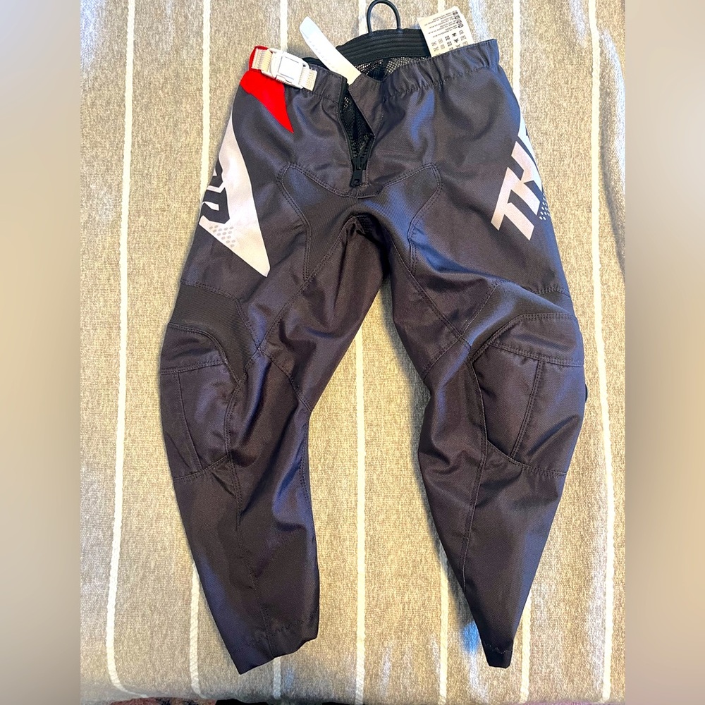Thor youth MX dirtbiking pants size 24 waist black with red and white accents